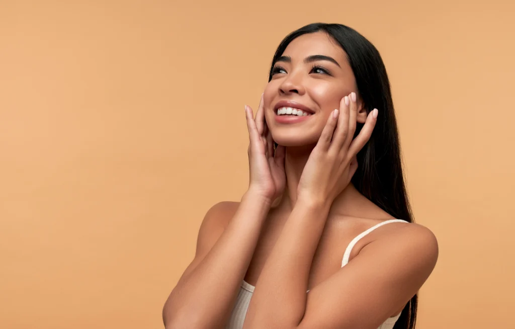 A woman with glowing and radiant skin smiling after a Hydrafacials treatment.